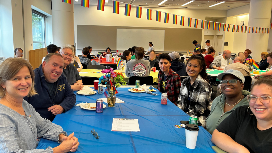 faculty, students, staff at table during a department event