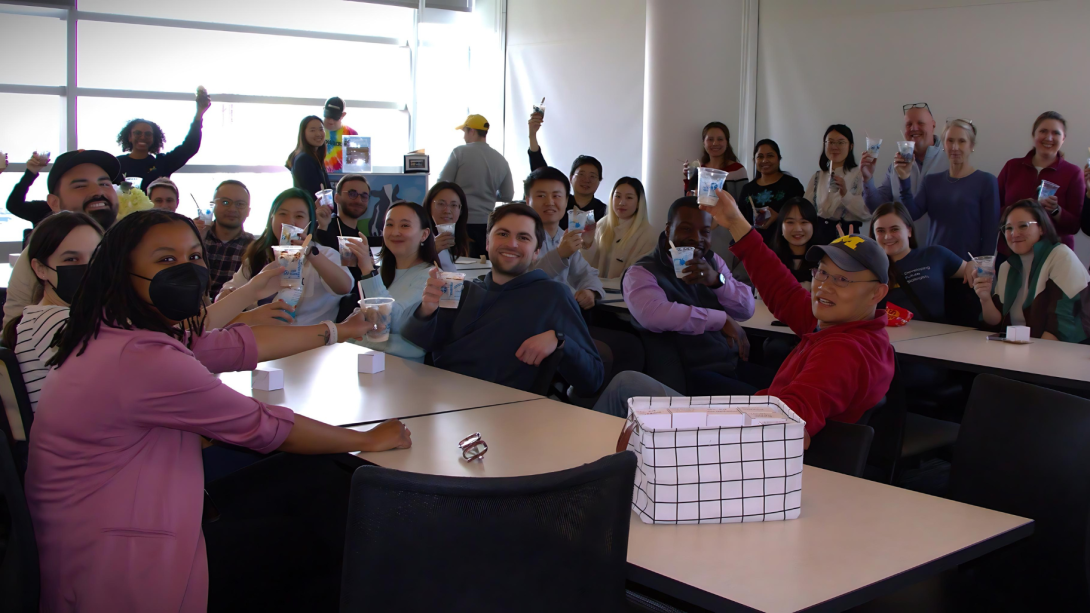 CDB faculty, students, staff raising cups at a department event