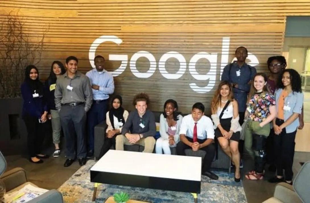 Group of people in front of a Google wall