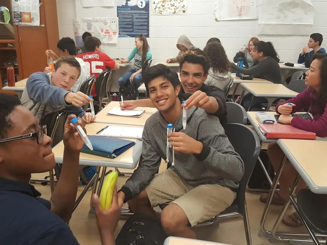 Young people holding a pen for a photo