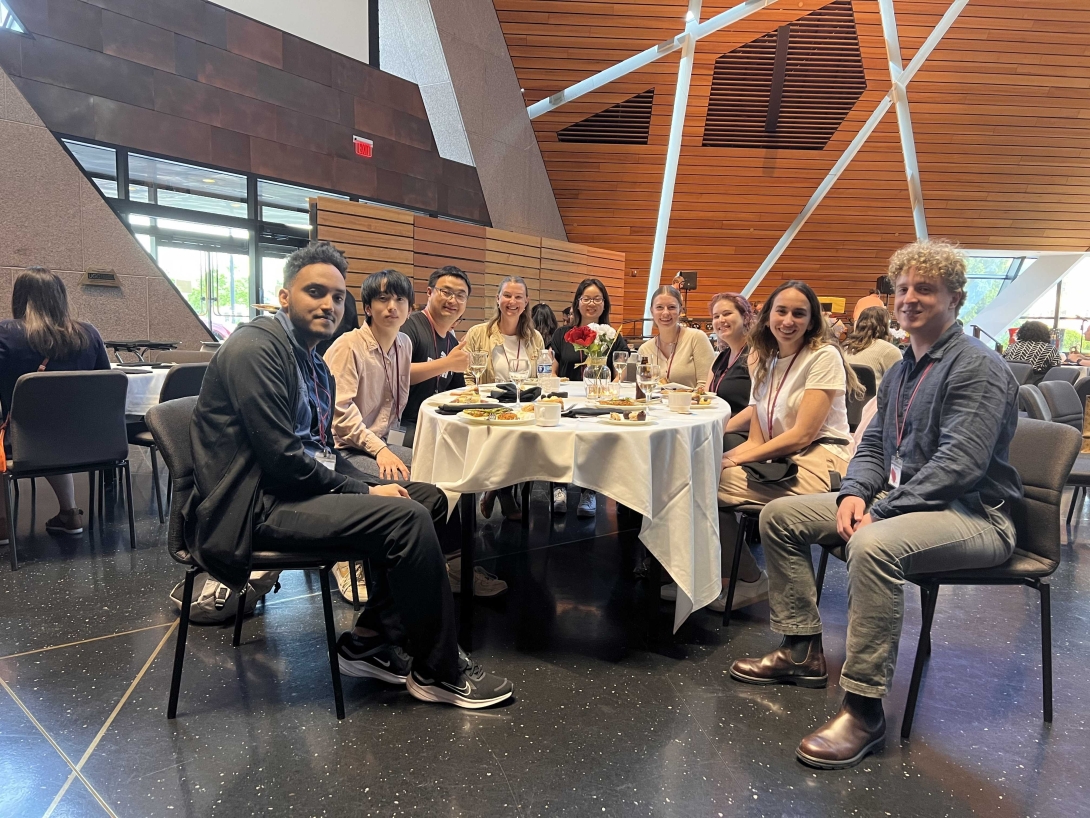 Lab members sitting on a table posing for the photo