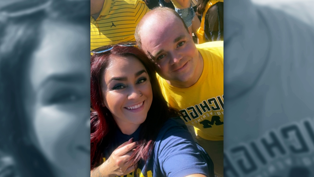 woman smiling with man in michigan gear selfie