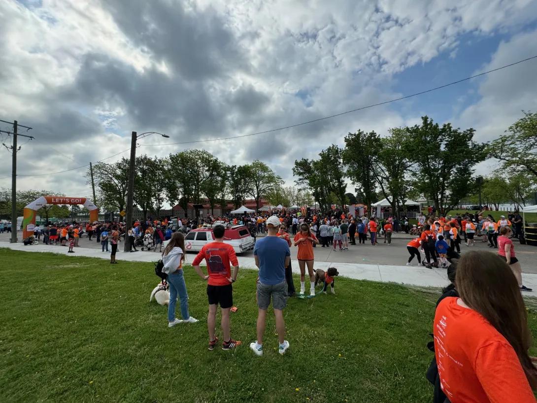 a crowd of people dressed in orange at the starting line of the Walk MS event