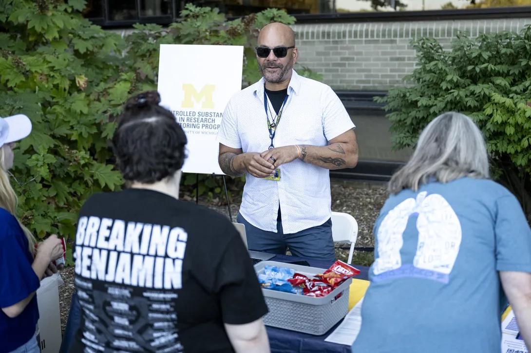 three people talking at table at outdoor event