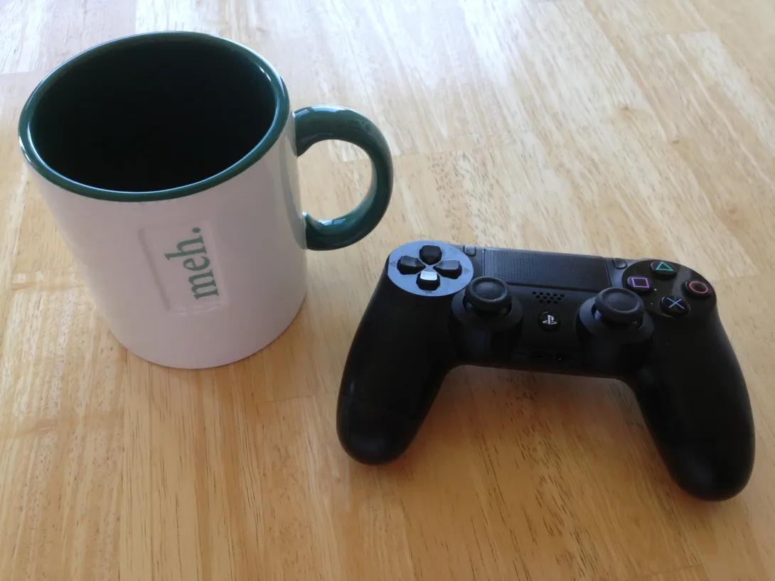 coffee cup and game controller sitting on table