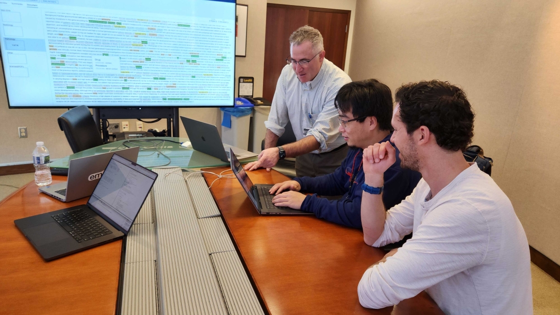 Dr. Hanauer and team in a conference room looking at laptops
