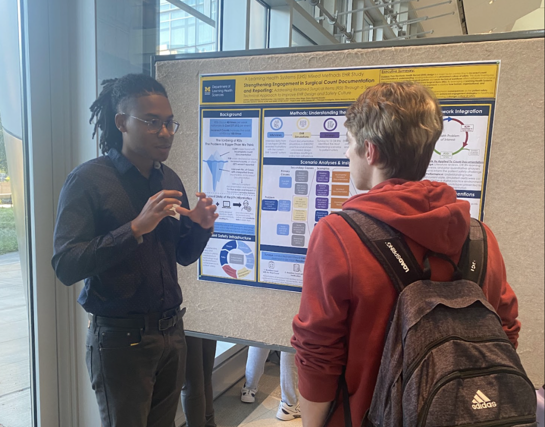 Photo showing Justus Dobson presenting at the PIBS poster session. Research presented in a poster entitled "Tackling the Wicked Problem of Retained Surgical Items: Using a Socio-Technical Approach to  Strengthen Engagement in Documentation and Reporting.