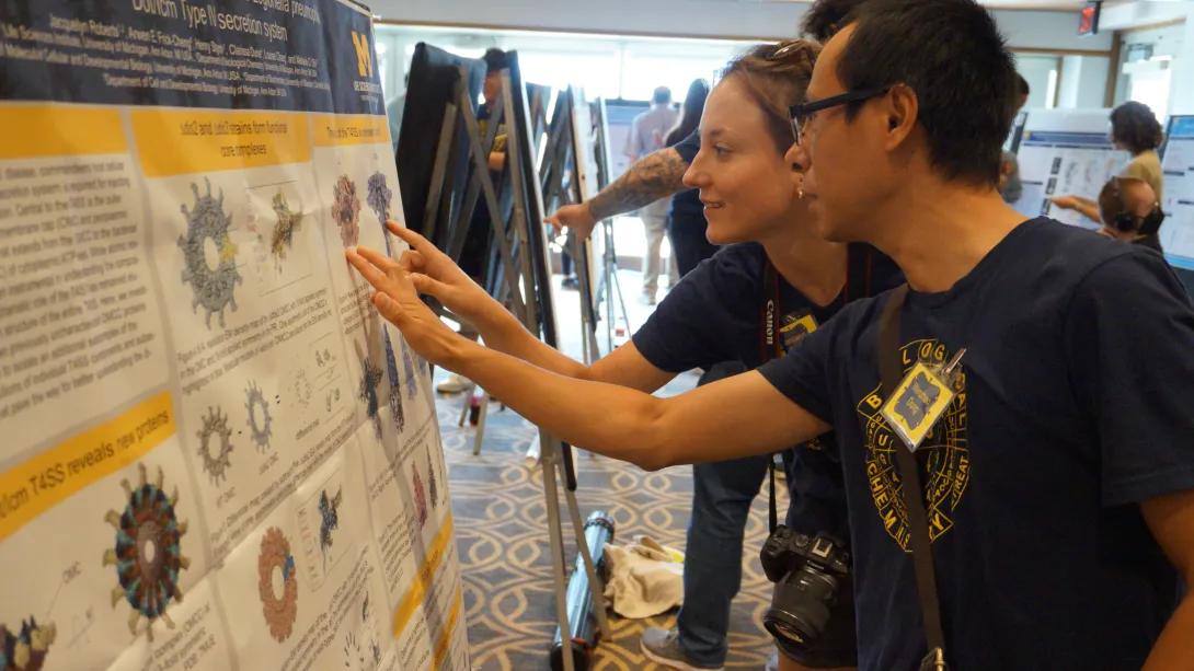 Scientists engaged in discussion at a research poster