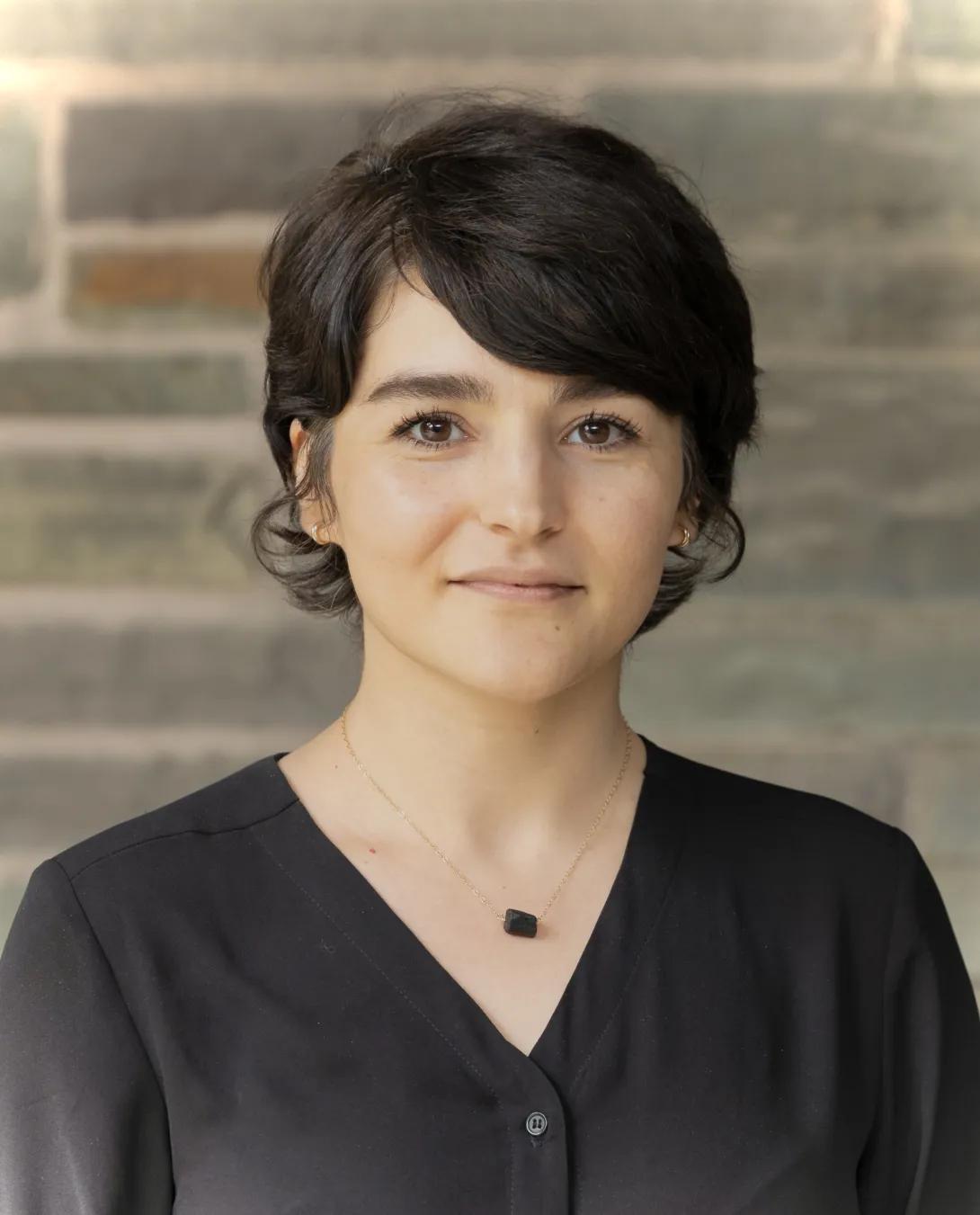 a young woman with short brown hair and a black shirt 