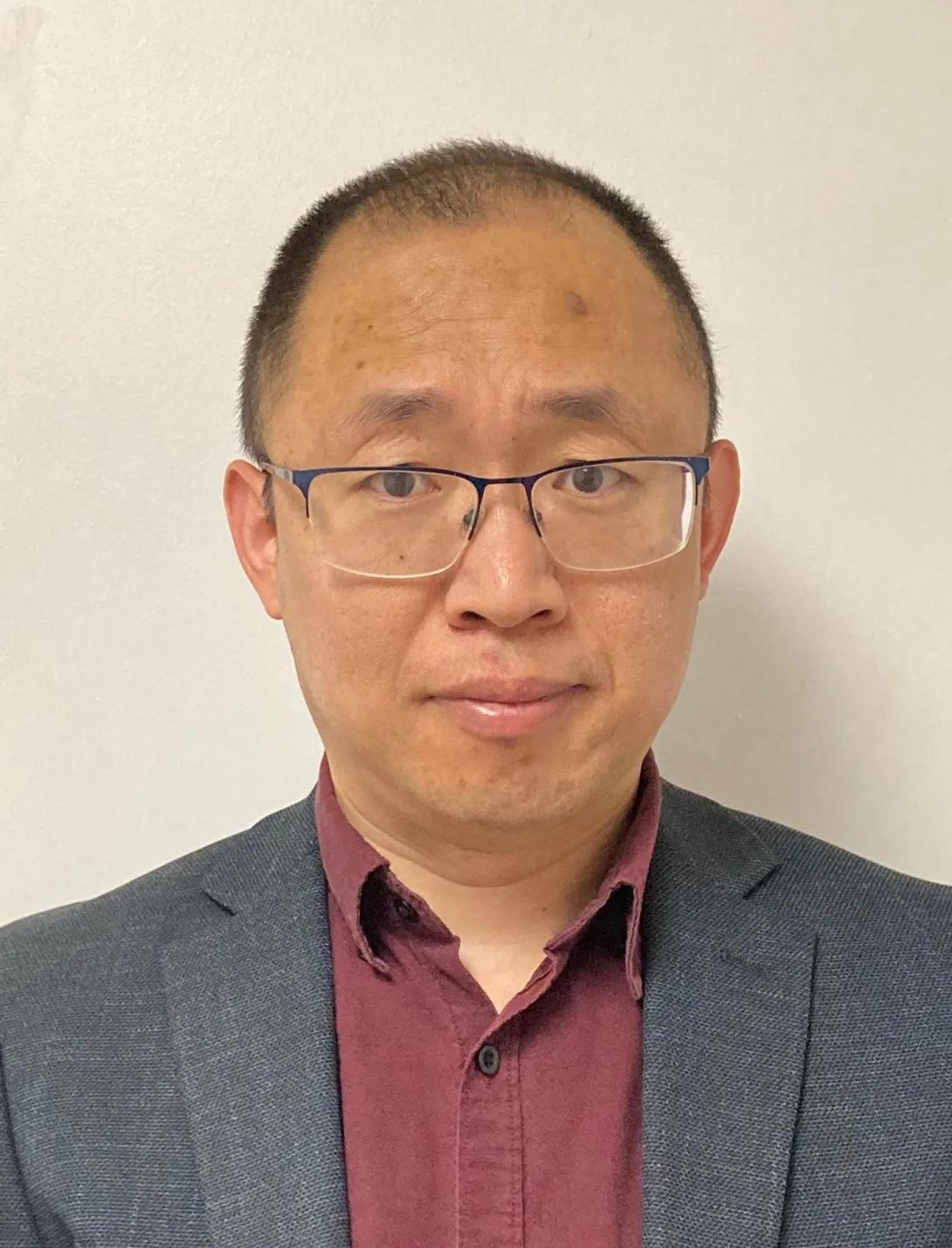 an Asian man with glasses 