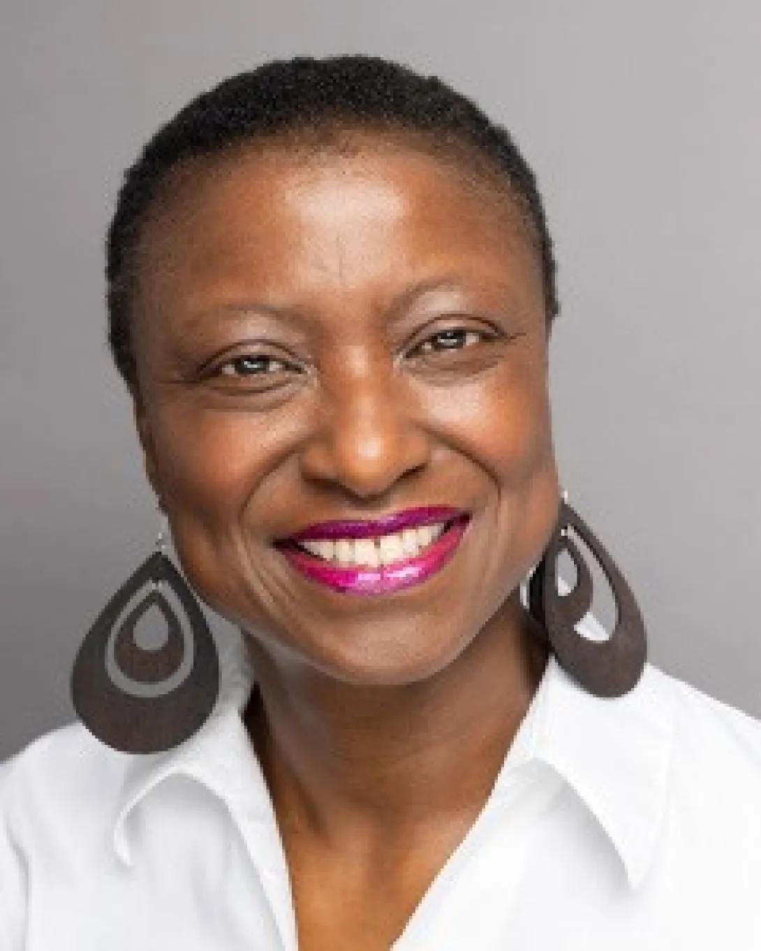 a Black woman with short hair and earrings 