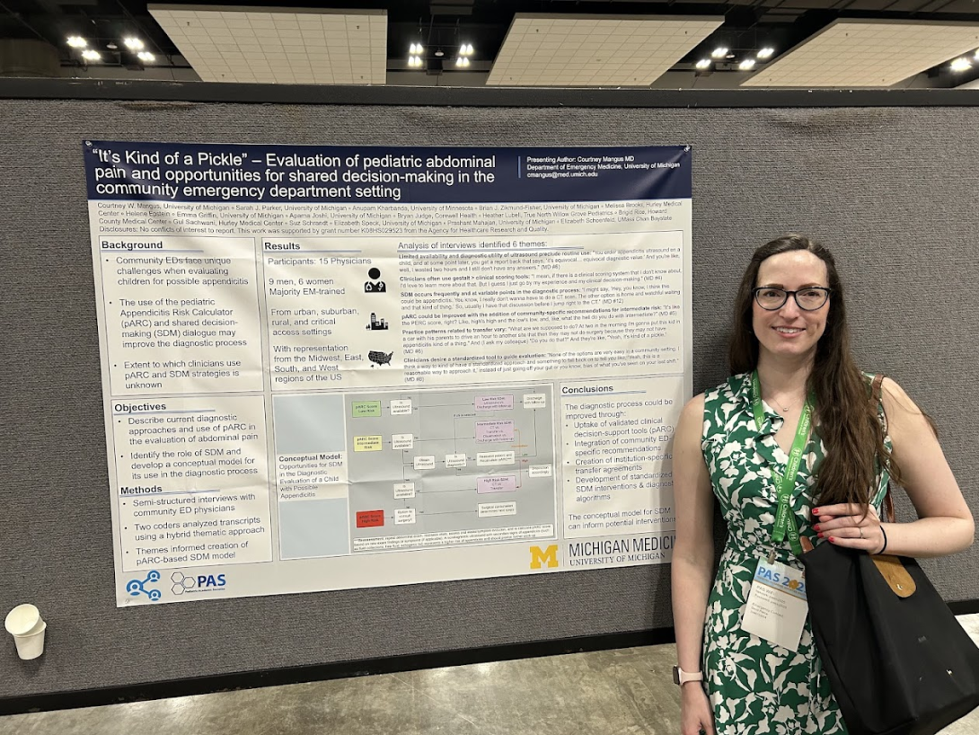 a PAS attendee poses in front of poster