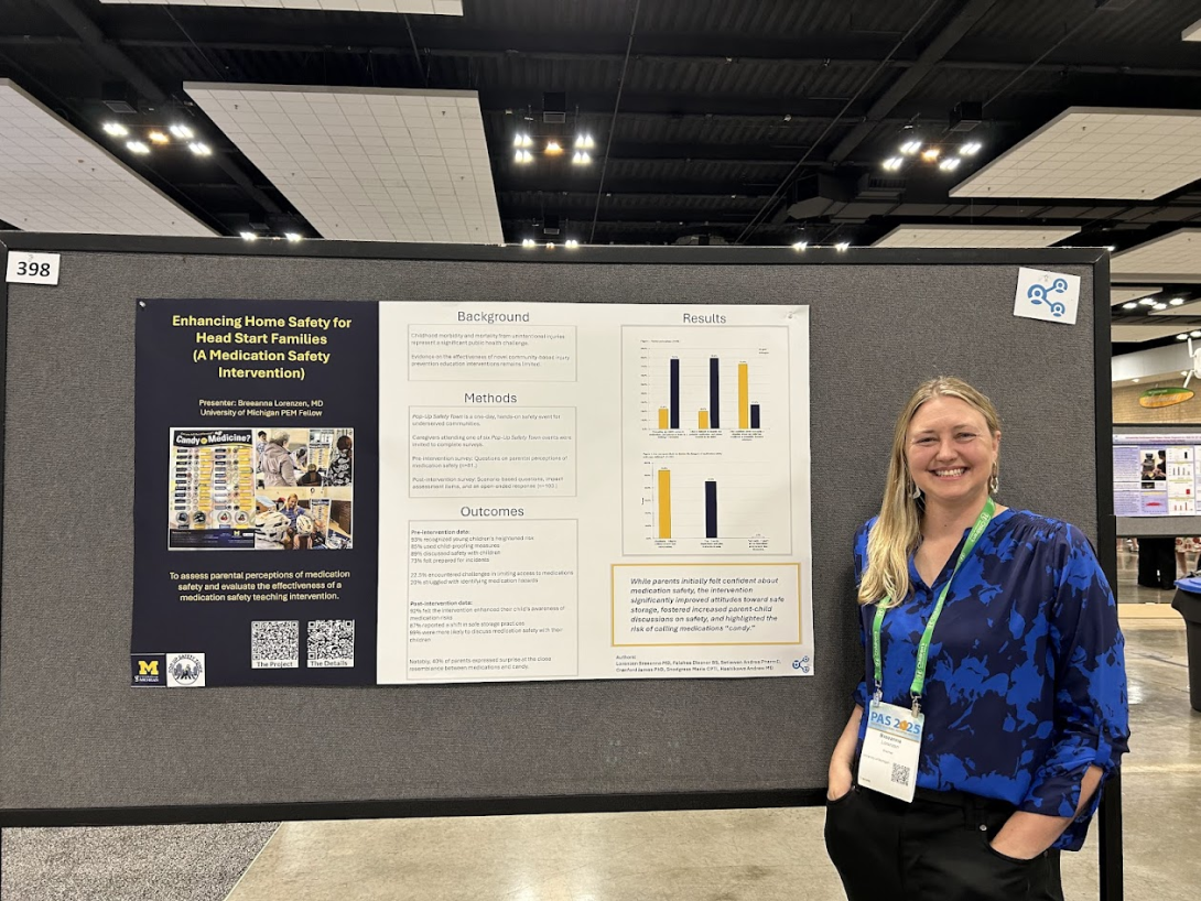 a PAS attendee poses in front of poster