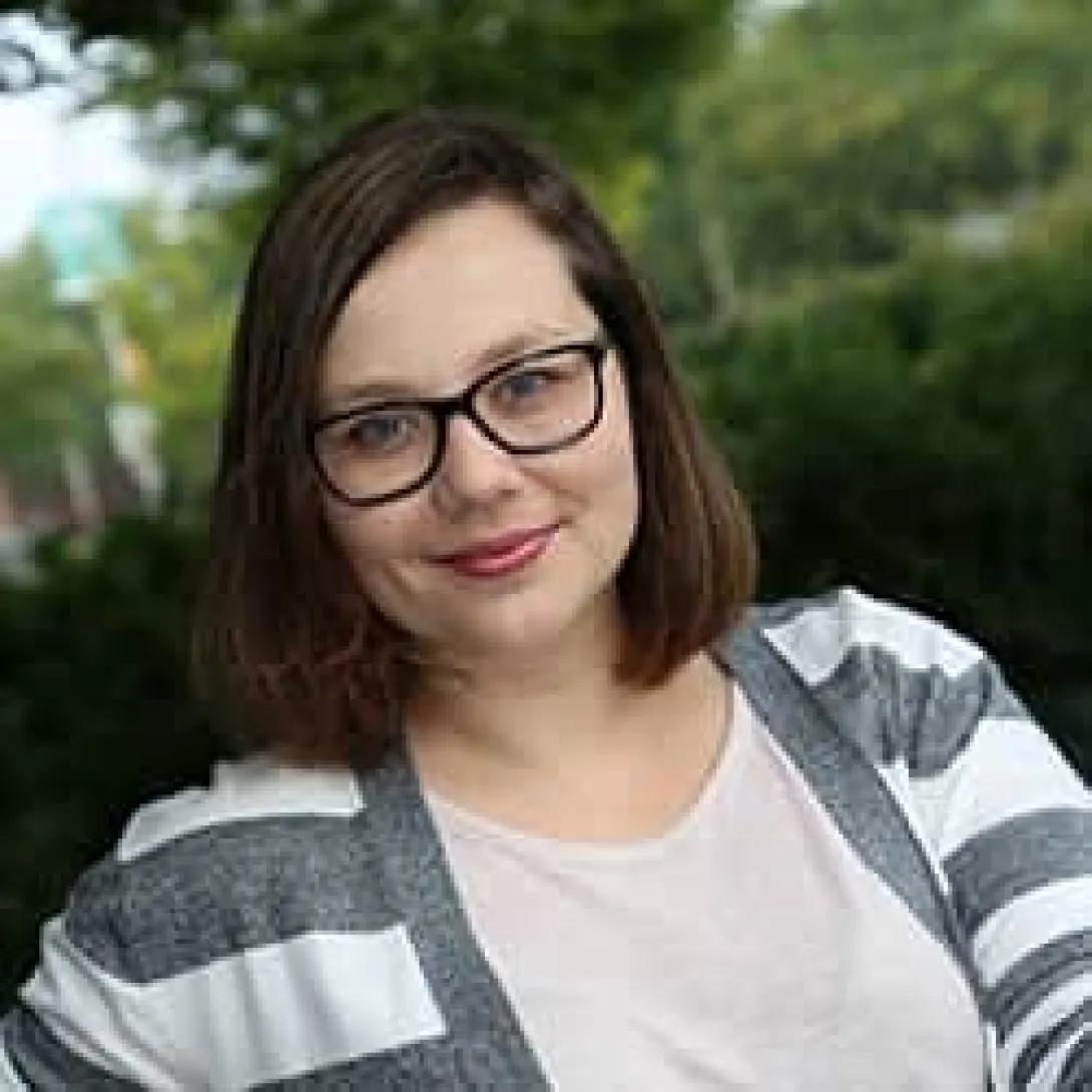 a woman with brown hair in a striped sweater
