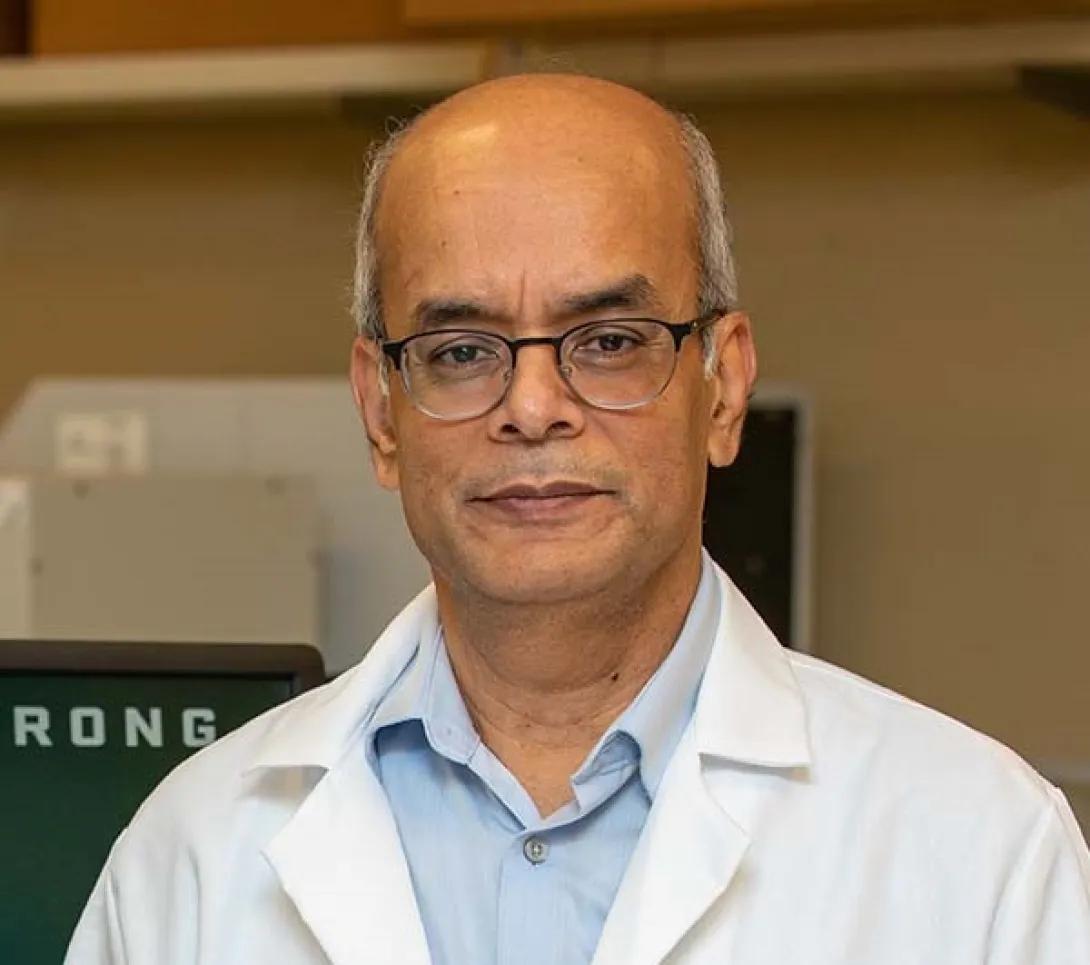 a bald man wearing a white coat 