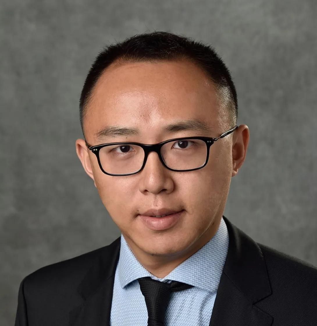 a young Asian man in a suit and tie 