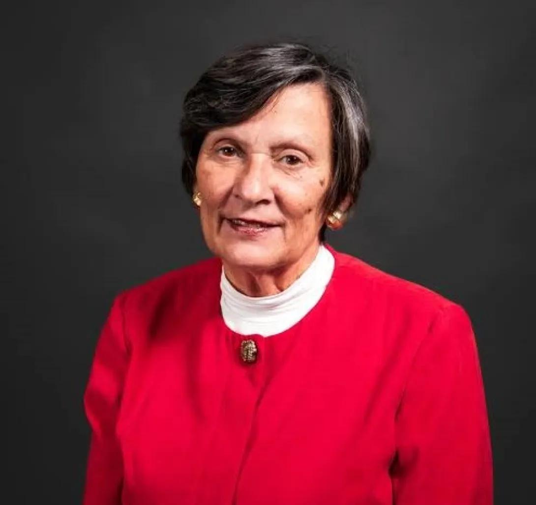 a woman with dark hair and a red coat