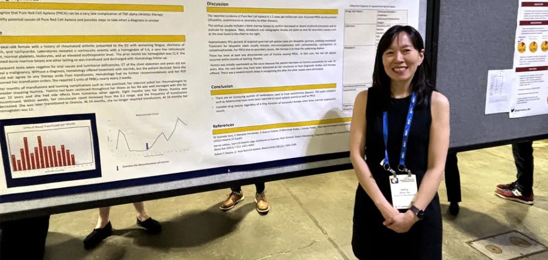 doctor standing next to research poster