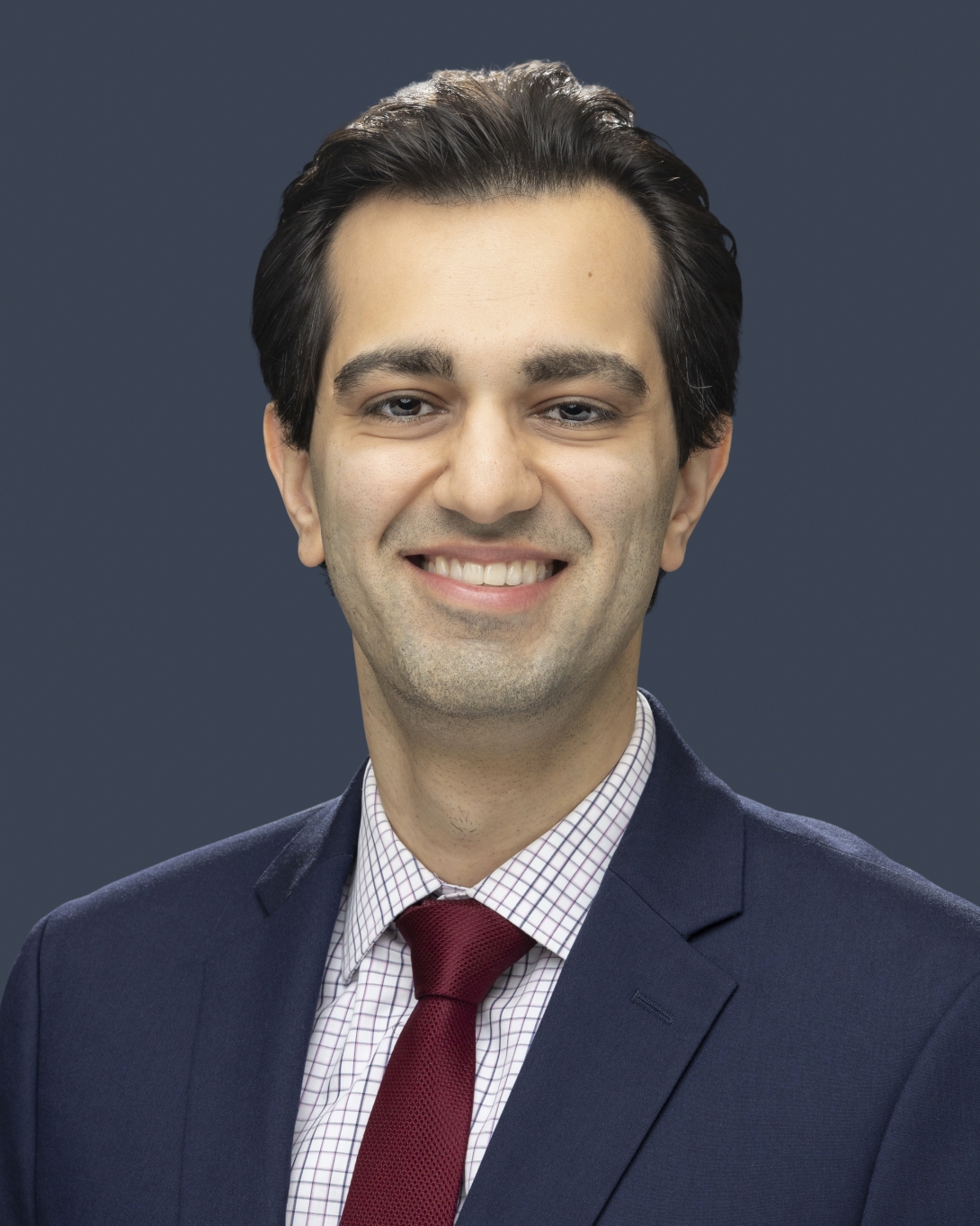 Smiling man in a dark suit with short dark hair