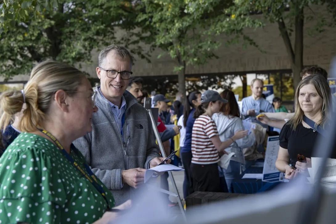 Photo of Dr. David Miller attending Researchpalooza and talking to staff at booth