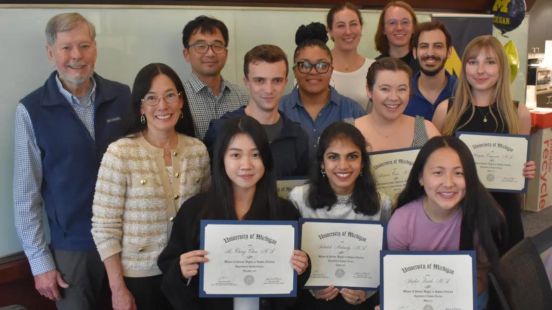 Group of team members and students with diplomas
