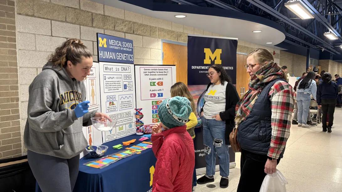 Students explaining a poster about human genetics