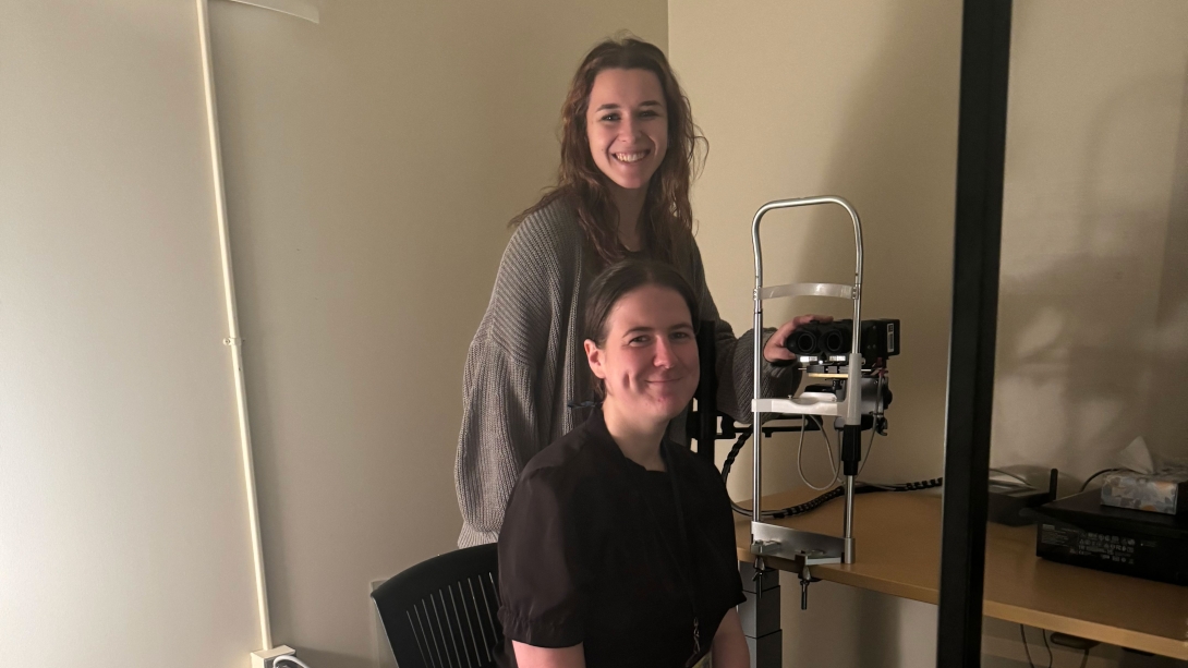 Two team members smiling next to equipment on a table in the sleep lab