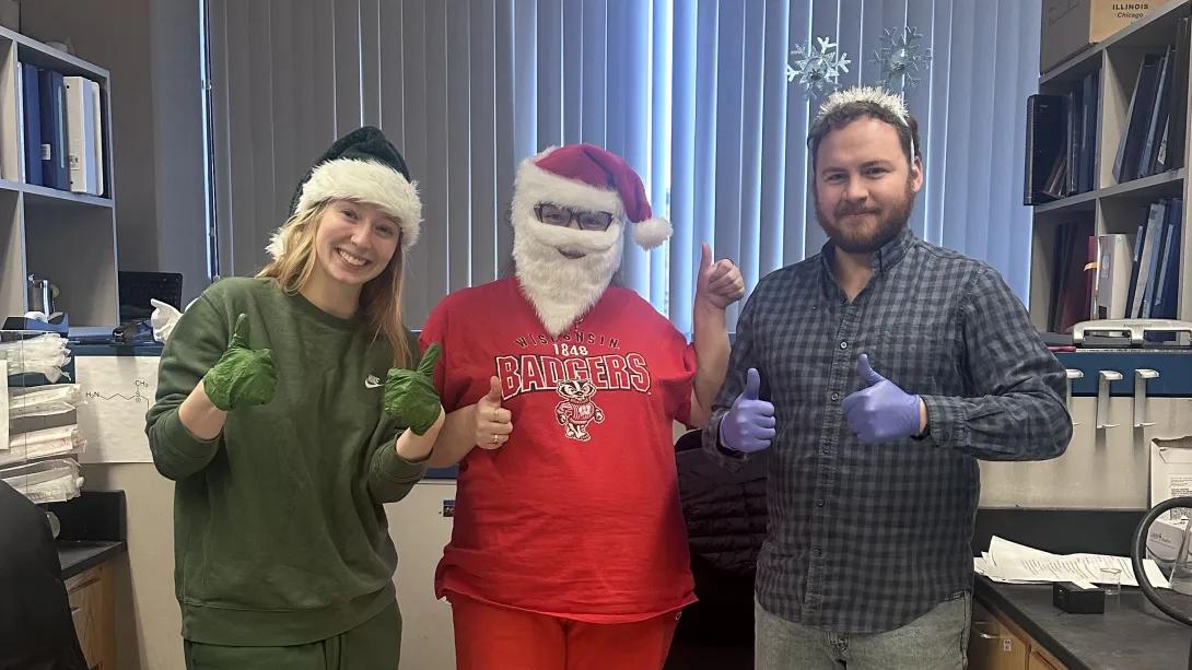 three people dressed in holiday garb in the lab