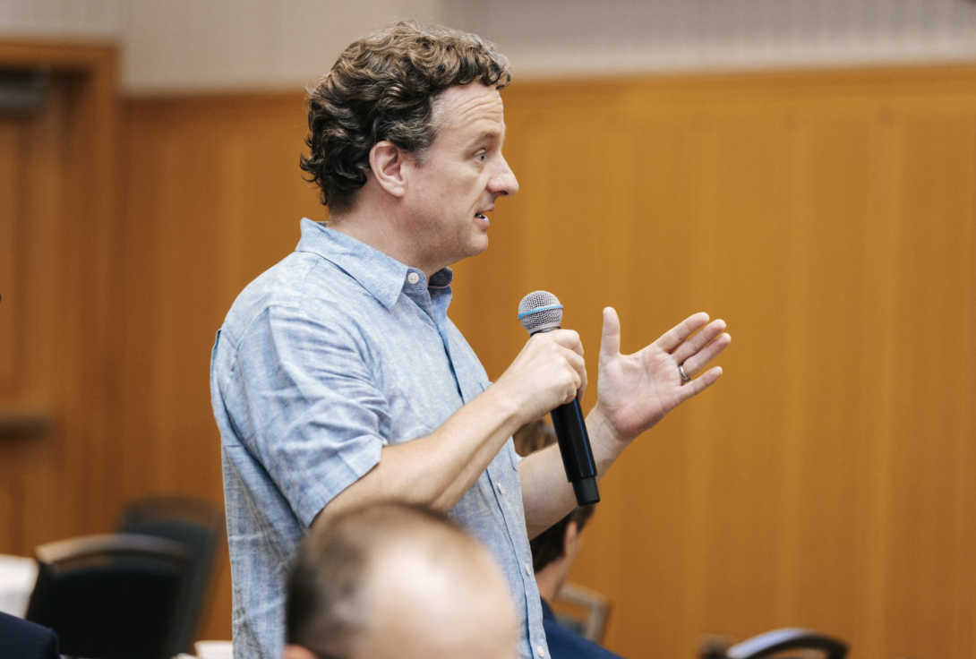 man asking a question, holding a microphone