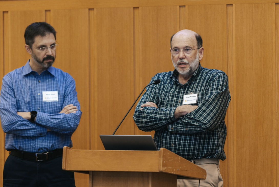 two men presenting at a symposium