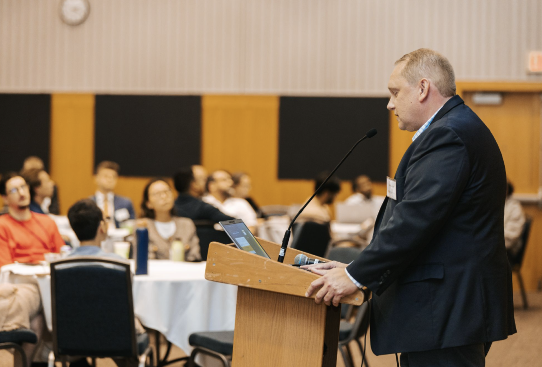 man presenting at a symposium