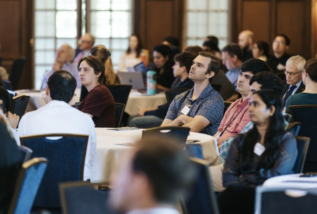 people sitting at round tables at an event