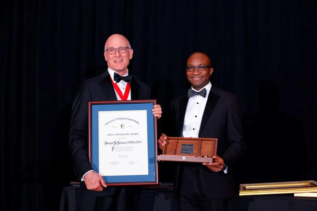 Two men at an awards ceremony posing for a photo