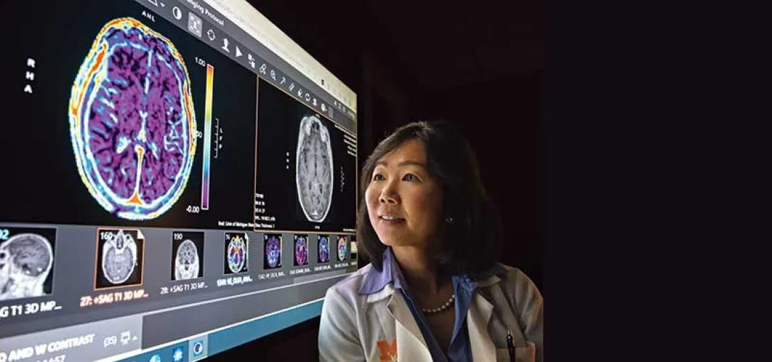 Dr. Michelle Kim stands before a brain scan