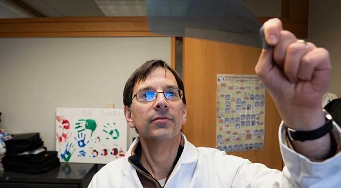 John Prensner, MD, PhD studies a scan