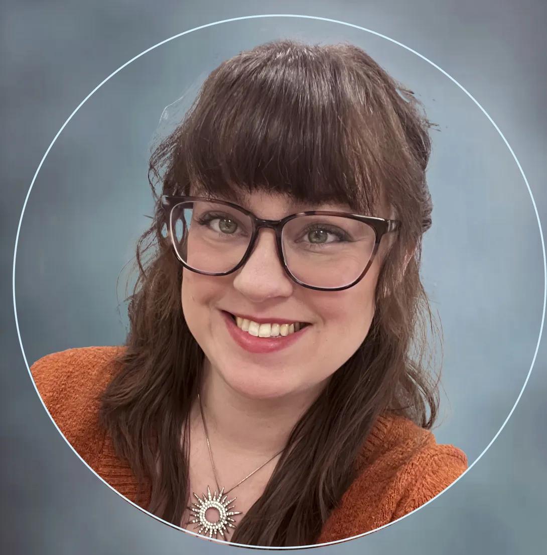 Rachel Brew - woman with brown hair and glasses wearing an orange sweater