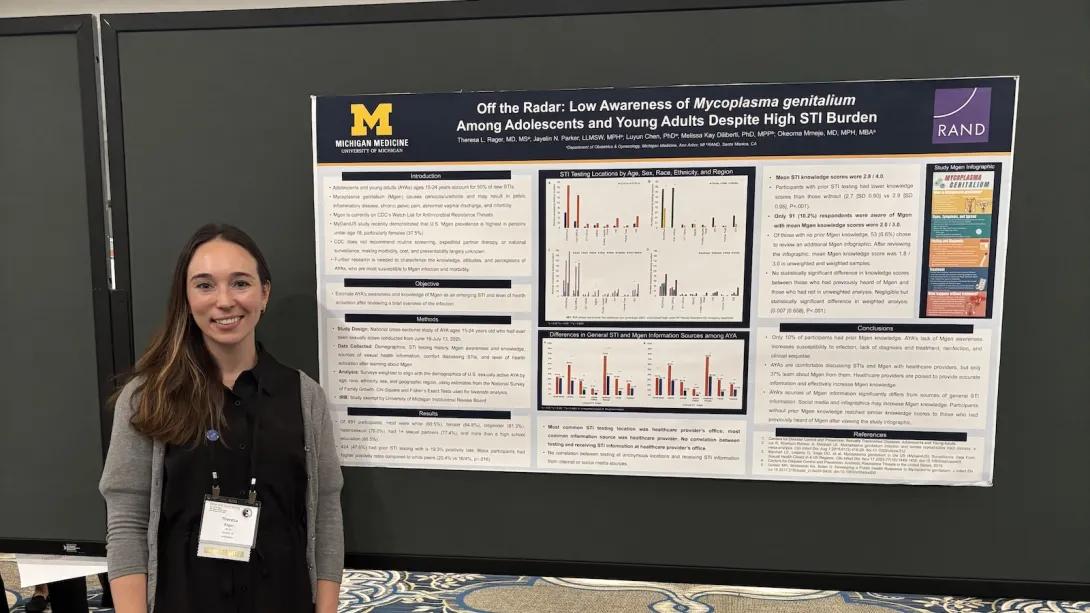 Reproductive Infectious Disease Research Group team member standing in front of research poster