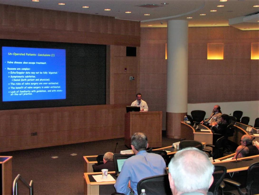 person presenting to a large auditorium of people