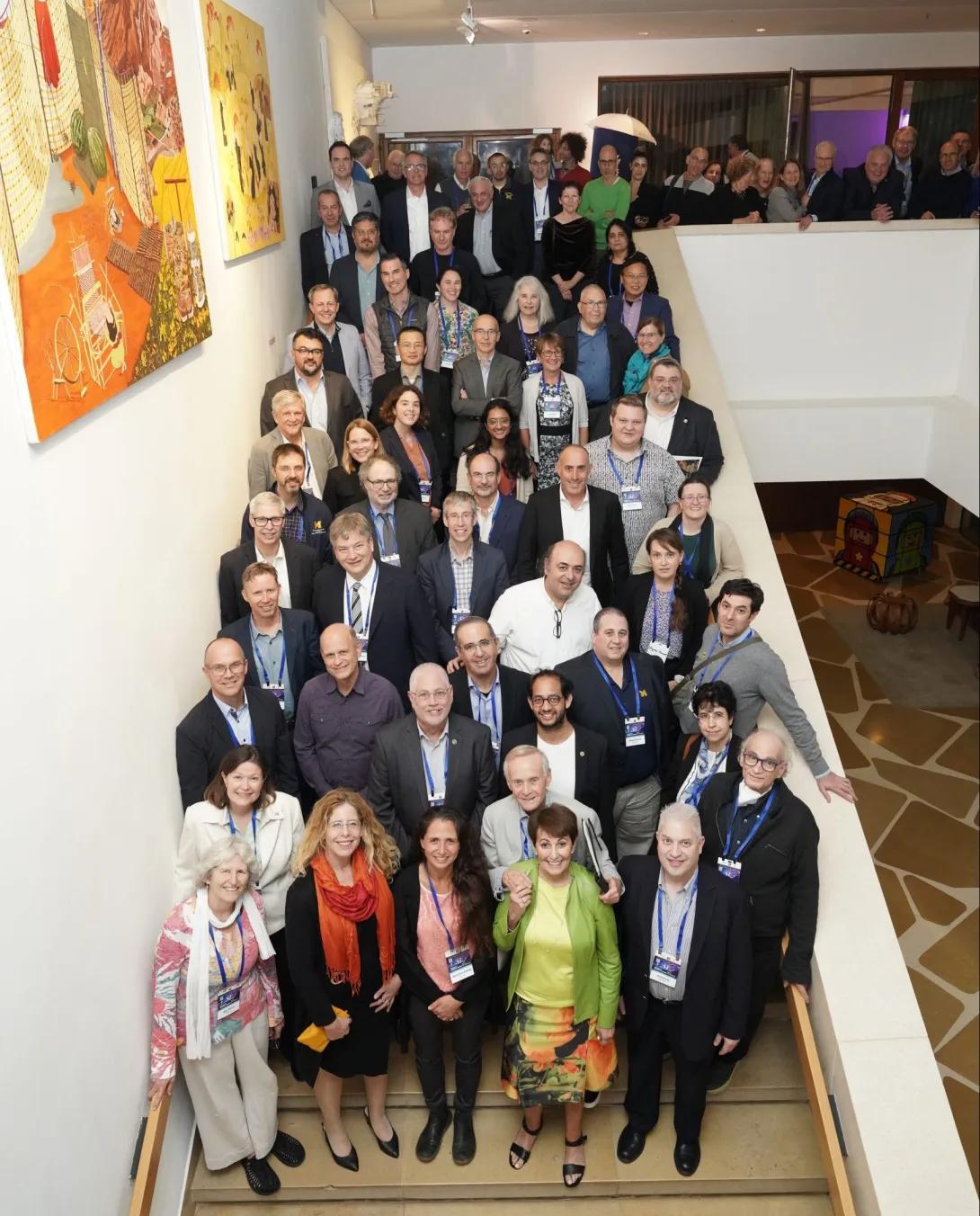 large group of people posing for a photo on a tall staircase