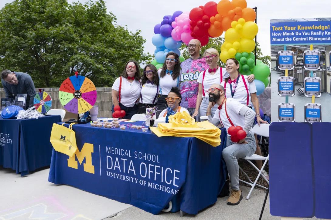 group of people posing for a photo at a tabling event outdoors