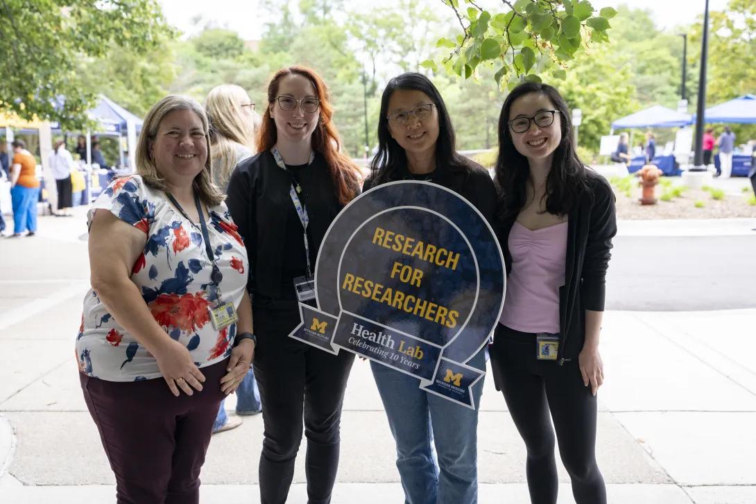 group of people posing for a photo and holding a sign