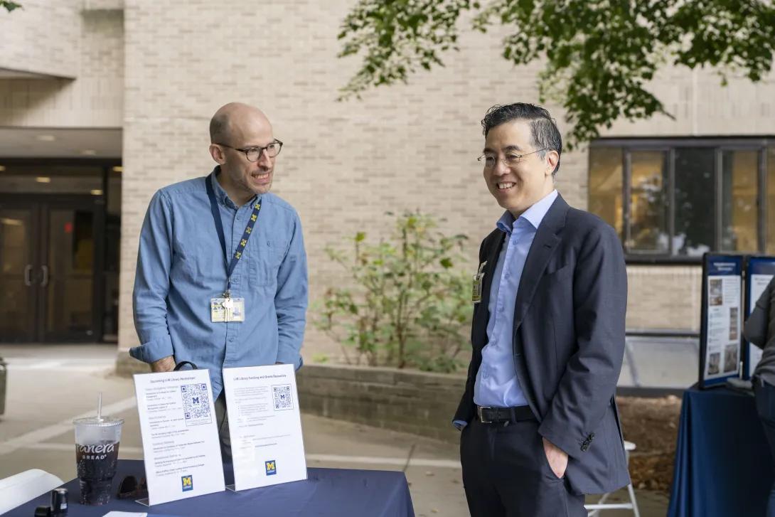 candid picture of people talking at a tabling event outdoors