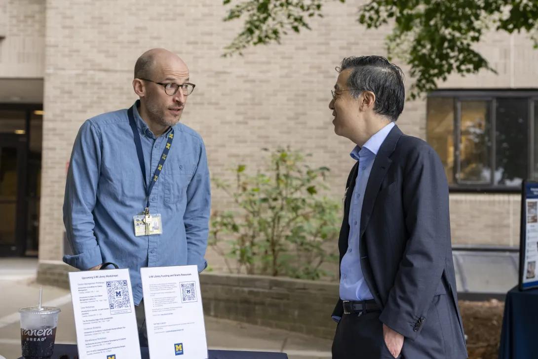 candid picture of people talking at a tabling event outdoors