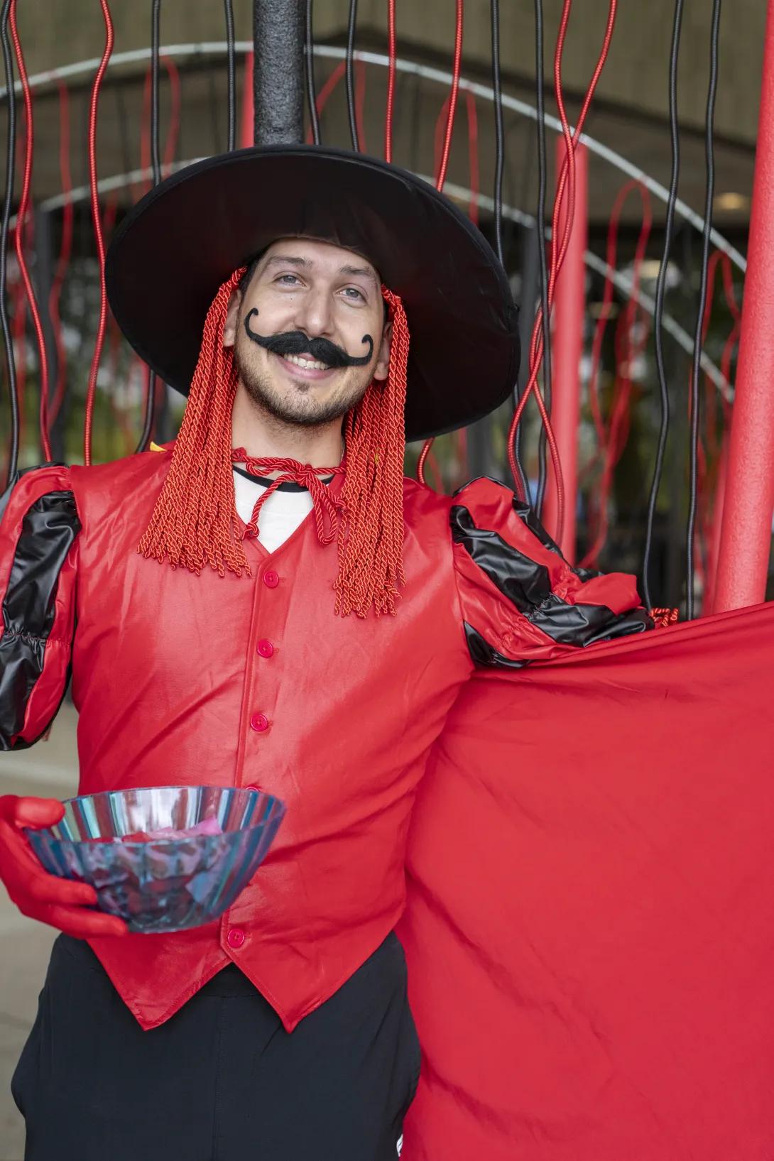 man in costume smiling at a tabling event outdoors