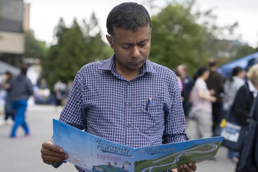 man looking at a event brochure at a tabling event outdoors
