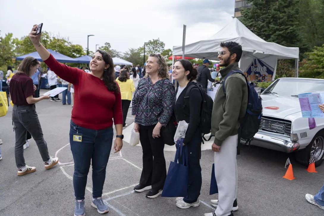 candid picture of people taking a selfie at a tabling event outdoors