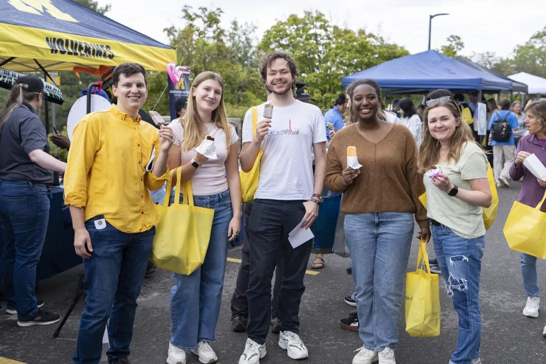 group of people posing for a photo at a tabling event outdoors