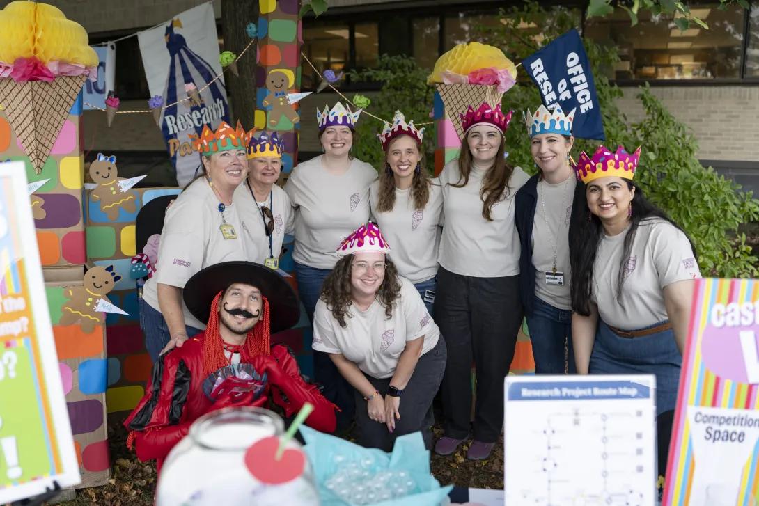group of people wearing costumes and posing for a photo at a tabling event outdoors