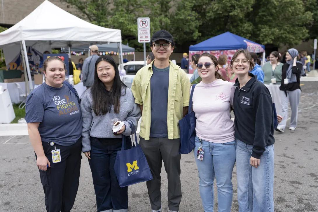 group of people posing for a photo at a tabling event outdoors