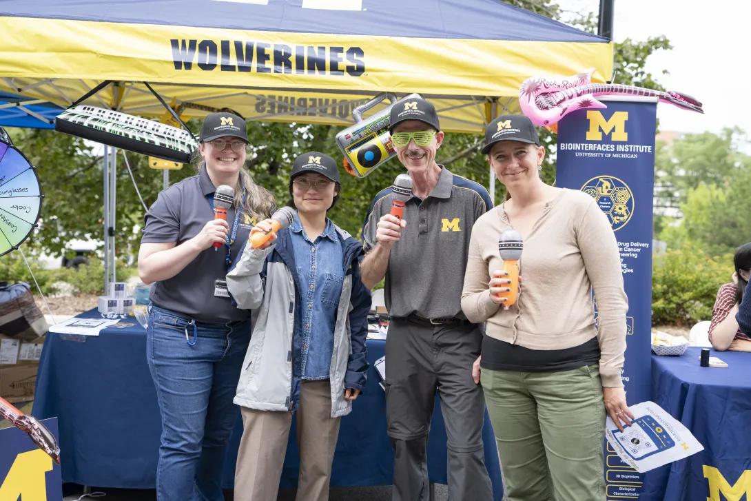 group of people posing for a photo at a tabling event outdoors